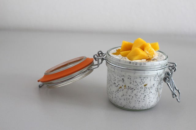 Glass of chia seed mixed in yogurt with fresh fruit on top